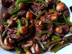 a white plate topped with meat and veggies on top of it's side