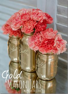 four gold mason jars with pink flowers in them