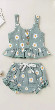 two pieces of clothing with daisies on the front and bottom, one in blue