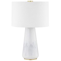 a white table lamp with a gold base and a white shade on the top of it