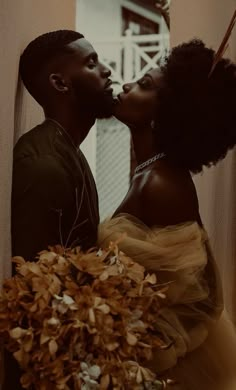 a man and woman kissing in front of a window