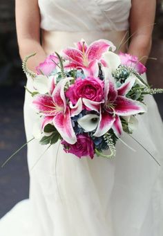 a bride holding a bouquet of pink and white flowers