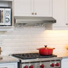 a stove top oven sitting inside of a kitchen next to a microwave and toaster oven