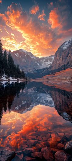 the sun is setting over a mountain lake