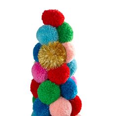 a stack of pom poms with a gold heart on top in front of a white background