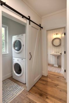 a white washer and dryer in a room with wood flooring next to an open door