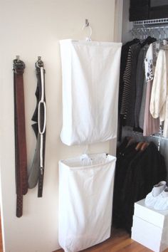 an organized closet with clothes hanging on the wall