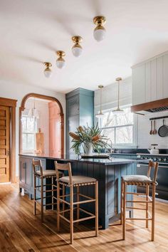 a kitchen with blue cabinets and wooden floors