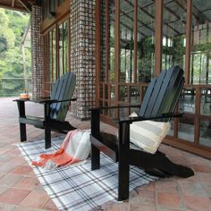 two wooden chairs sitting on top of a checkered rug