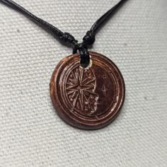 a necklace with a wooden medallion on it