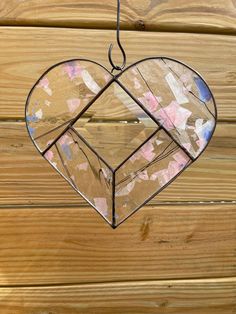 a stained glass heart hanging on a wooden wall