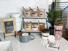 a kitchen counter topped with lots of different types of spices and containers filled with hot chocolate