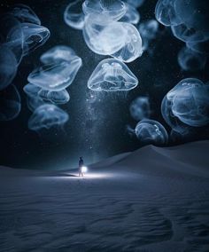 a person standing in the middle of an ocean filled with jellyfish under a night sky