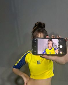 a woman holding up a cell phone to take a selfie in front of her face