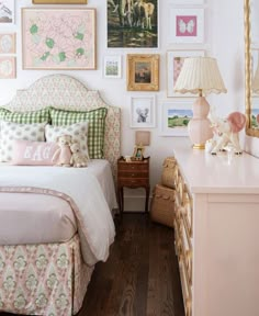 a bedroom with pictures on the wall above the bed and dresser in front of it