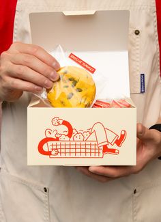 a person holding a box with some food in it