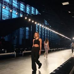 two models walking down the runway at a fashion show