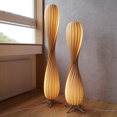 two tall lamps sitting on top of a wooden floor