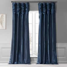 a blue curtain with ruffled edges hanging in front of a white wall and window