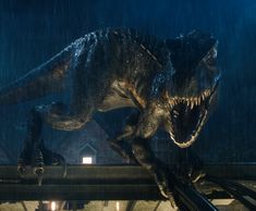 a large dinosaur standing on top of a train track in the rain with it's mouth open