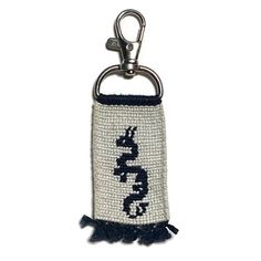 a keychain with an embroidered snake on it's side and tasseled ends