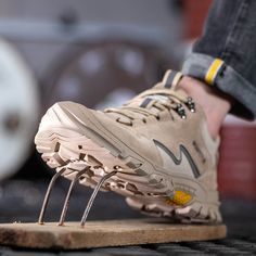 a person standing on top of a wooden board with metal spikes in their shoelaces