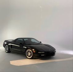 a black sports car parked in a white room