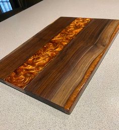 a wooden cutting board sitting on top of a counter next to a knife holder with wood inlays