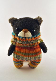 a teddy bear wearing a colorful sweater and scarf