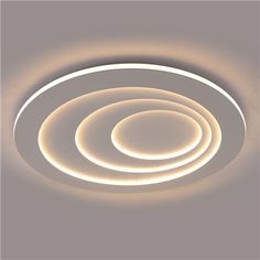 a circular light fixture with dim lighting on the ceiling and two circles in the center