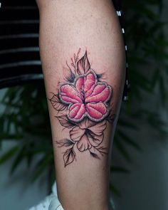 a close up of a person's leg with a flower tattoo on the thigh