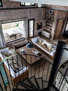 an aerial view of a living room and dining area from the second floor balcony looking down