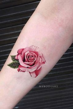 a pink rose tattoo on the arm