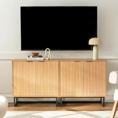 a flat screen tv sitting on top of a wooden cabinet