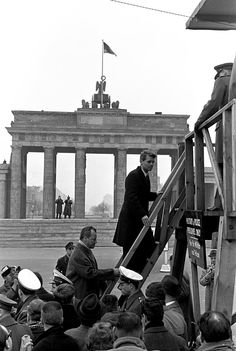 black and white photograph of man walking up steps in front of the berliner dom