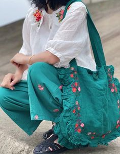 a woman sitting on the ground with a handbag