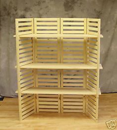 a wooden shelf with shutters on the top and bottom, sitting on a wood floor