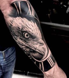 a man with a tattoo on his arm has an eagle clock in it's head