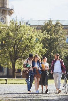 group of people walking in the park with bicycles