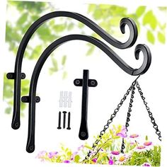 three black wrought iron brackets hanging from the side of a tree with flowers in the background