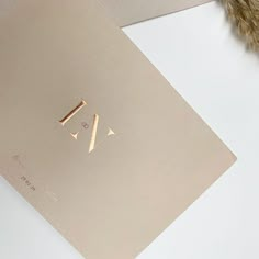 a gold card with the letter y on it next to a feather and some other items