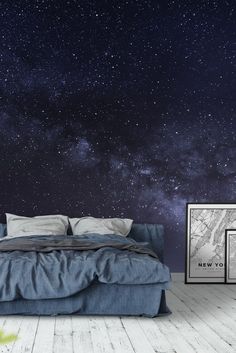 a bedroom with a bed, night sky and two framed pictures on the wall next to it