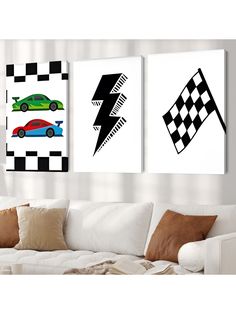 three paintings on the wall of a living room with a white couch and two racing cars