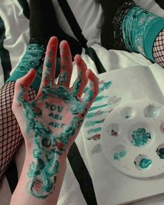 someone has their hands painted with blue and white paint