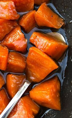 cooked carrots are in a pan with a spoon