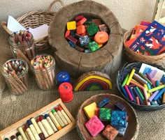 several baskets filled with different colored crayons and pencils next to each other