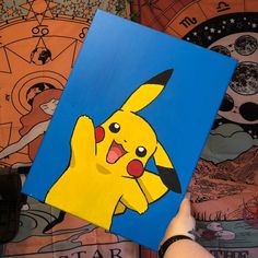 someone is holding up a painting of pikachu