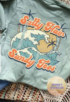 Salty Hair and Sandy Toes beach shirt is super cute-perfect for the beach!Super fun and cute!  Available on a soft unisex tee.  This is dusty blue in the listing pic but as always you can choose your favorite shirt color.  Color and size chart are in the 4th and 5th listing pictures.Soft unisex tees are a little big for ladies sizing.  I usually recommend if you dont mind a looser fit with slightly longer length most are fine in their normal ladies size.  If you prefer something more fitted go d Beach Tshirt Designs, Beach Shirt Design, Ocean Shirt, Beach Logo, Beach Vintage, Beach Tee, Salty Hair, Cute Shirt Designs, Baseball Mom Shirts