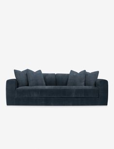 a dark blue couch with four pillows on it's back and one arm facing the camera