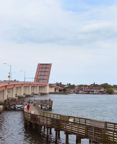 people are walking on the bridge over the water